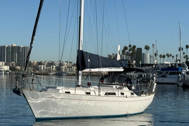 Slide: The Image of 1985 Passport 40 sailboat docked in marina, cityscape and palm trees in background. - 3