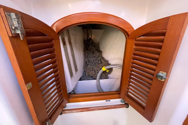 Slide: The Image of Wooden cabinet with open doors revealing coiled rope and hose inside. Passport 40, 1985 model. - 31