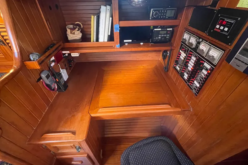 Slide: The Image of 1985 Passport 40 yacht navigation station with wooden desk, communication equipment, and control panels. - 33