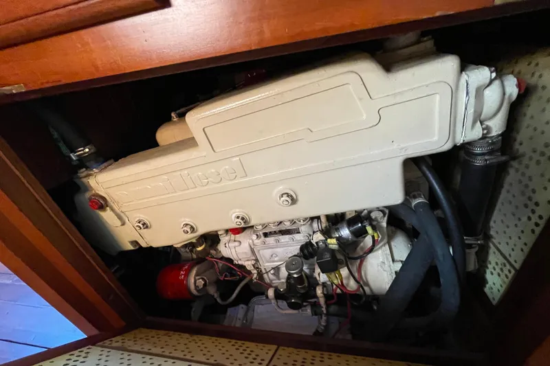 Slide: The Image of Engine compartment of a 1985 Passport 40 sailboat, featuring a diesel engine. - 39