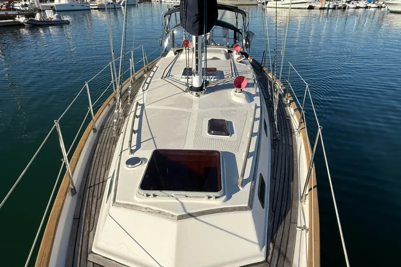 Slide: The Image of 1985 Passport 40 sailboat deck view in marina, showcasing sleek design and craftsmanship. - 4