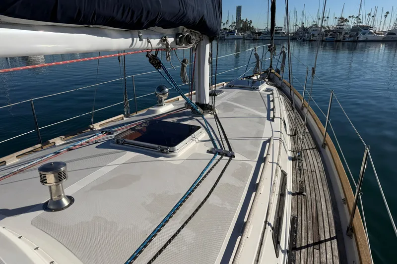 Slide: The Image of Sailboat deck view of 1985 Passport 40, docked in a marina with clear blue water. - 5
