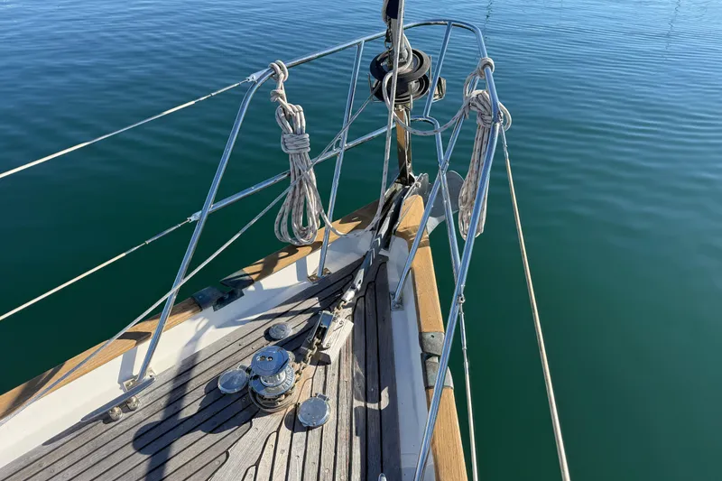 Slide: The Image of Bow of 1985 Passport 40 sailboat with ropes and calm water. - 6