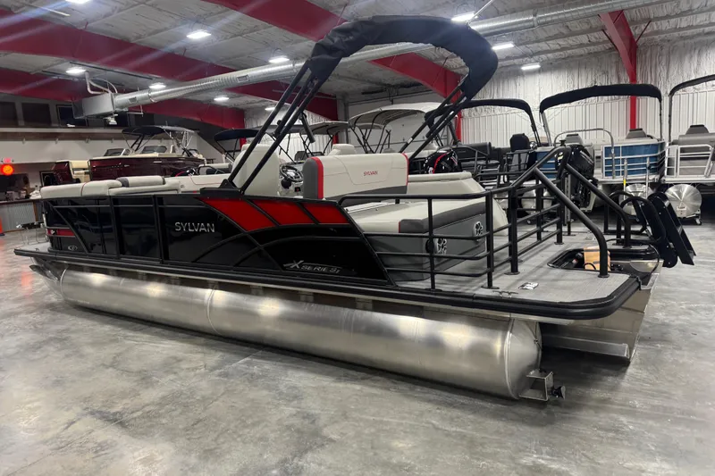 Slide: The Image of 2026 Sylvan X 5 pontoon boat in showroom, featuring sleek black and red design. - 4