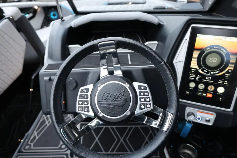 Slide: The Image of Steering wheel and touchscreen of 2022 Tigé 24RZX boat interior. - 28