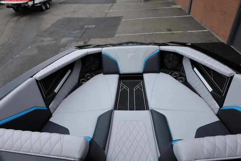 Slide: The Image of 2022 Tigé 24RZX boat interior with gray and blue upholstery, featuring cup holders and speakers. - 32