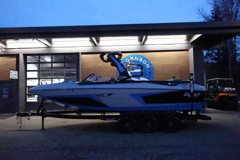 Slide: The Image of 2022 Tigé 24RZX boat on trailer, parked outside a building at dusk. - 43
