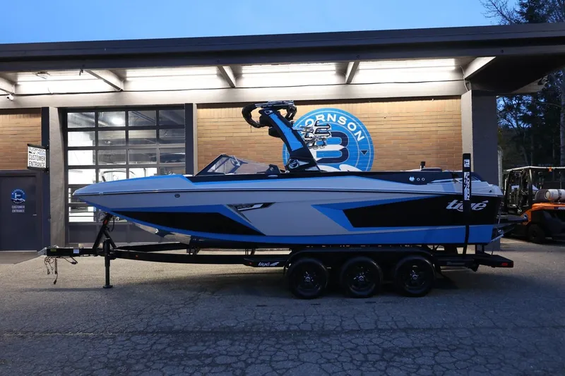 Slide: The Image of 2022 Tigé 24RZX boat on trailer, parked outside a building at dusk. - 44