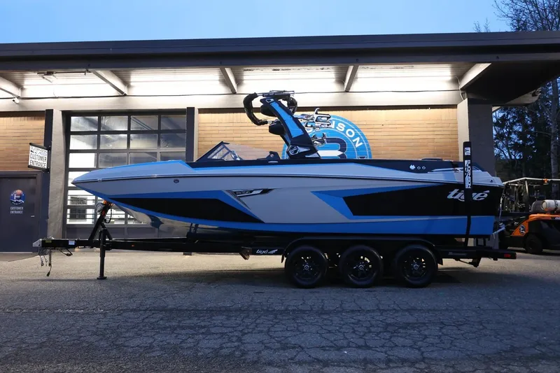 Slide: The Image of 2022 Tigé 24RZX boat on trailer, parked outside a building at dusk. - 45