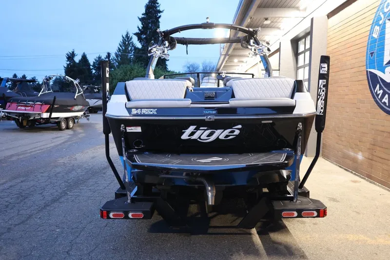 Slide: The Image of 2022 Tigé 24RZX boat rear view at marina, showcasing sleek design and features. - 48