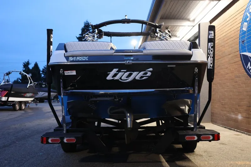Slide: The Image of 2022 Tigé 24RZX boat, rear view, parked at a marina during dusk. - 49