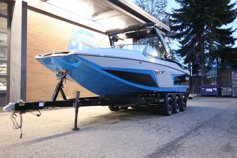 Slide: The Image of 2022 Tigé 24RZX boat on trailer, parked outdoors near a building. - 57