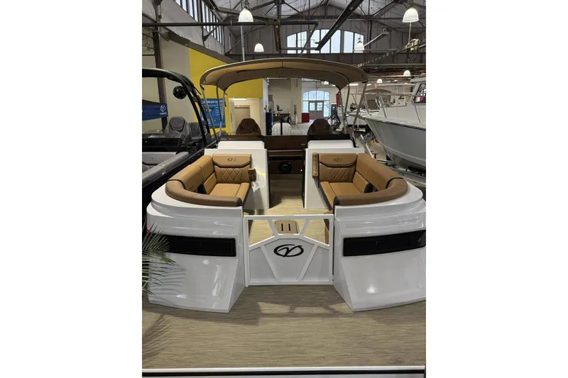 Slide: The Image of 2025 Veranda VX 25 DCVL pontoon boat with tan seating in showroom. - 2