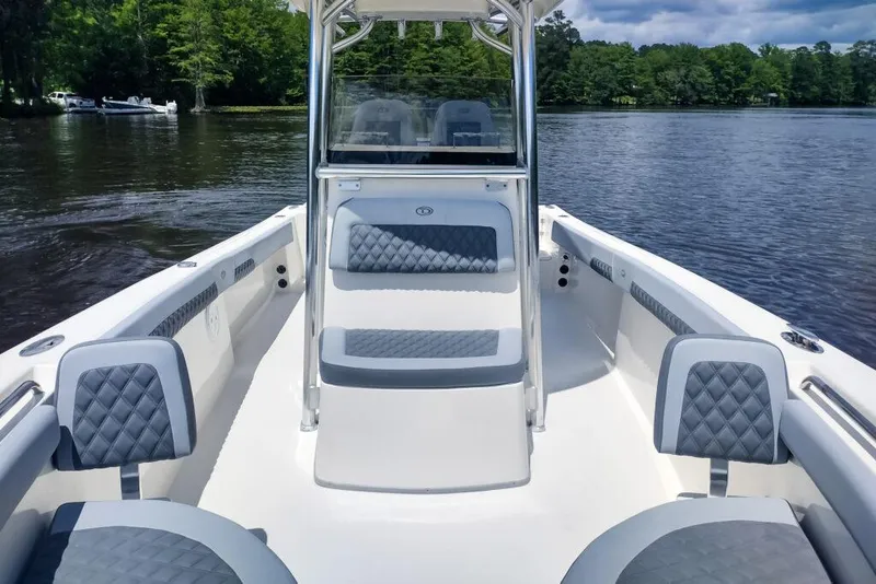 Slide: The Image of Manufacturer Provided Image: 2025 Defiance Catalina 240 boat interior with cushioned seating on a calm lake. - 19