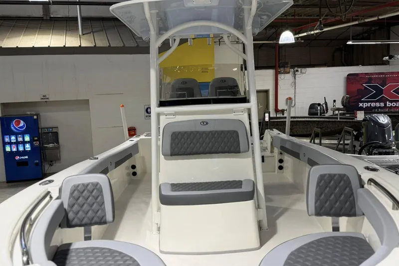 Slide: The Image of 2025 Defiance Catalina 240 boat interior with gray seating, displayed in a showroom. - 2