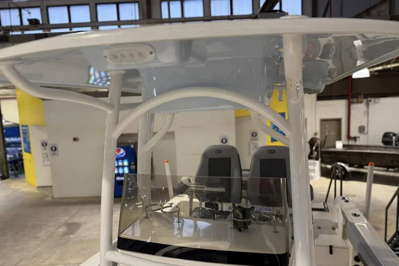 Slide: The Image of 2025 Defiance Catalina 240 boat interior with seating and console in a showroom. - 7