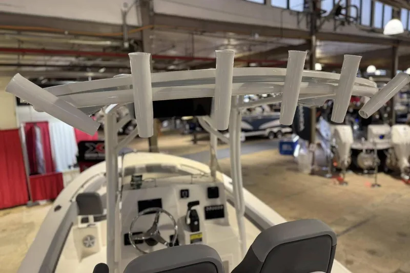 Slide: The Image of 2025 Defiance Catalina 240 boat interior with rod holders and steering wheel in showroom. - 9