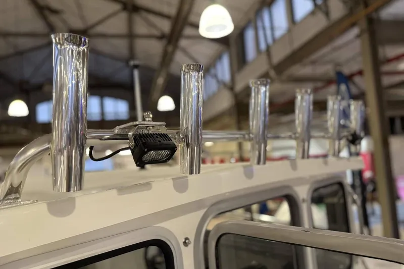 Slide: The Image of Rod holders and light on 2025 Defiance Admiral 220 EX boat in a showroom. - 5