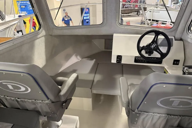 Slide: The Image of Interior of 2025 Defiance Admiral 220 EX boat with steering wheel and seating. - 6