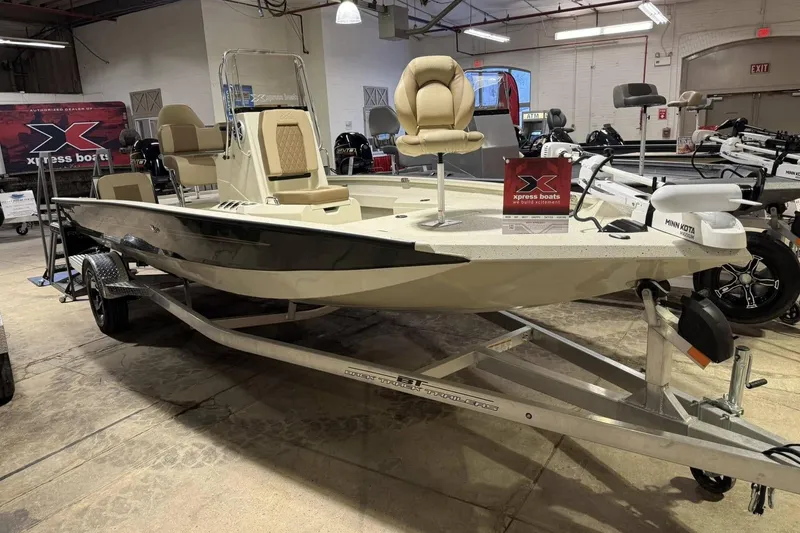 The Image of 2025 Xpress H20B Bay boat on display in showroom with trailer. - 0