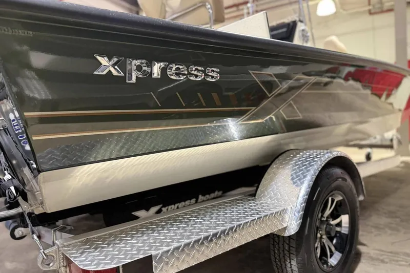 Slide: The Image of 2025 Xpress H20B Bay boat on a trailer, showcasing sleek design and branding. - 1