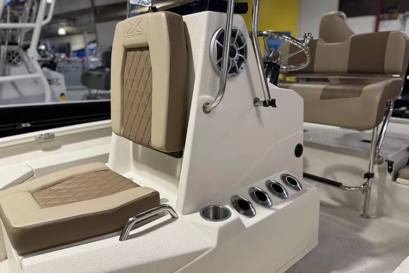 Slide: The Image of 2025 Xpress H20B Bay boat interior with beige seating and steering console. - 8