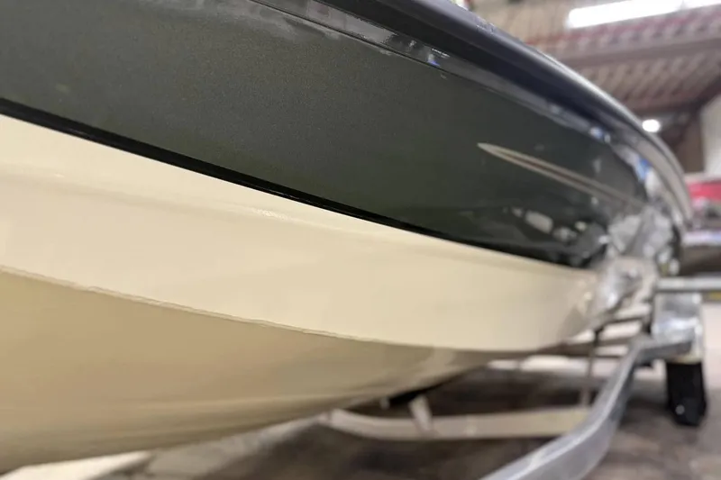 Slide: The Image of 2025 Xpress H20B Bay boat close-up, showcasing sleek hull design in a showroom. - 9