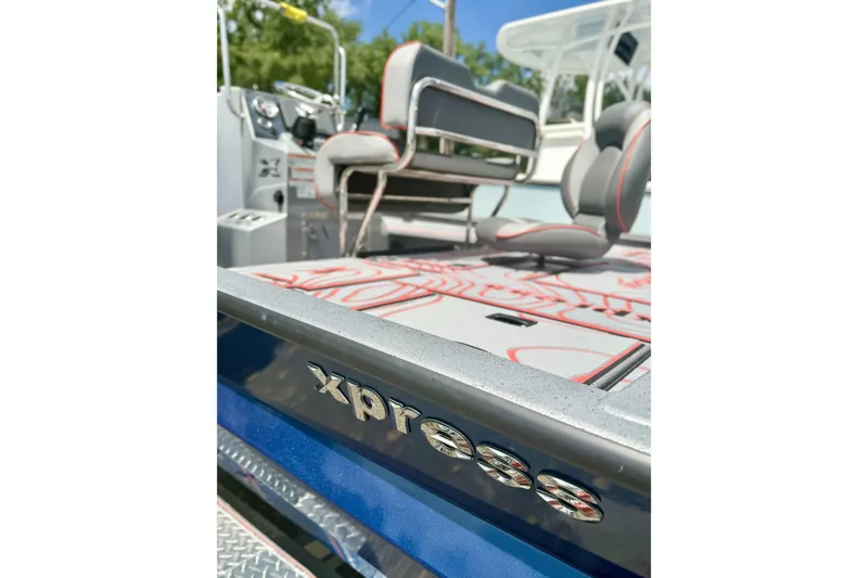 The Image of 2025 Xpress X23B Bay Lounge boat interior with seating and logo detail. - 0