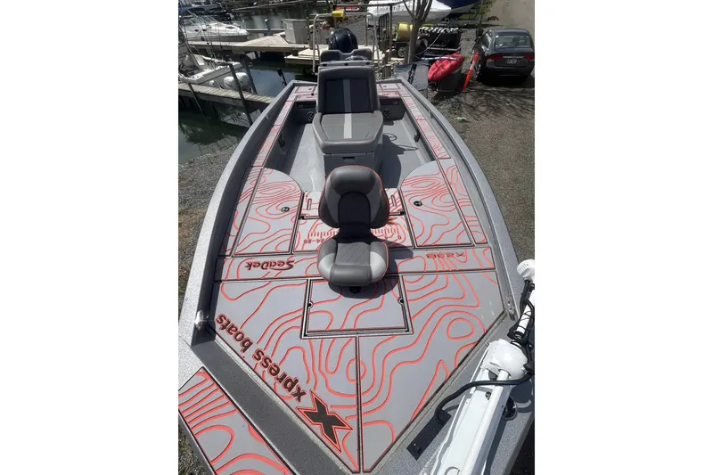 Slide: The Image of 2025 Xpress X23B Bay Lounge boat with stylish deck design at marina. - 2