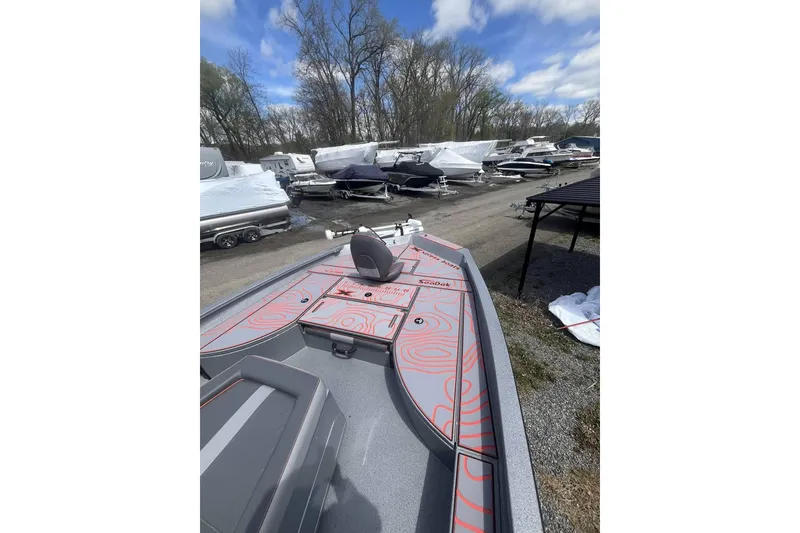 Slide: The Image of 2025 Xpress X23B Bay Lounge boat in storage yard, surrounded by other covered boats. - 5