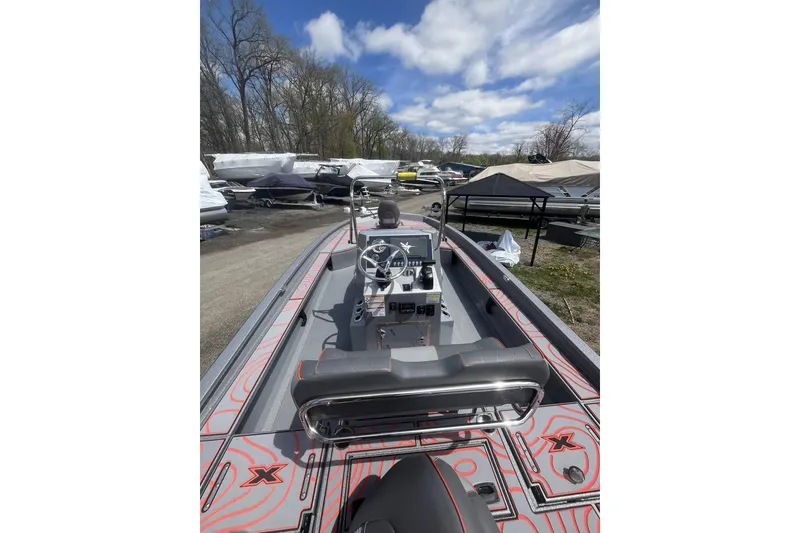 Slide: The Image of 2025 Xpress X23B Bay Lounge boat with sleek design, parked outdoors under blue sky. - 6