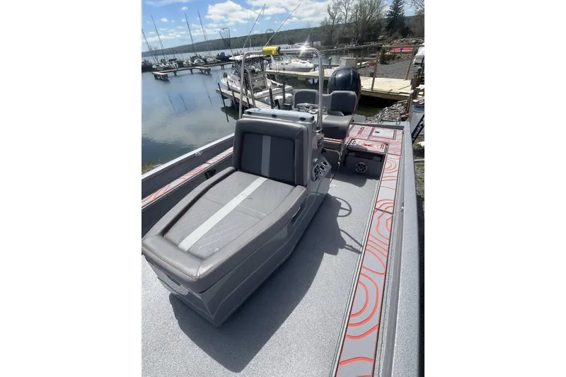 Slide: The Image of 2025 Xpress X23B Bay Lounge boat with sleek seating, docked by a serene marina. - 8