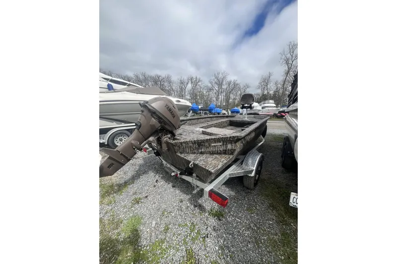 Slide: The Image of 2025 Xpress H16DB boat with Yamaha motor on trailer, parked outdoors. - 2