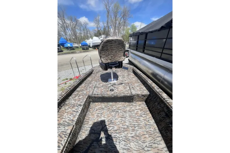 Slide: The Image of 2025 Xpress H16DB boat with camouflage interior, parked outdoors under blue sky. - 3