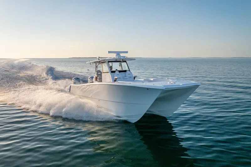 Slide: The Image of 2026 Freeman 35 boat cruising on calm ocean waters at sunset. - 2