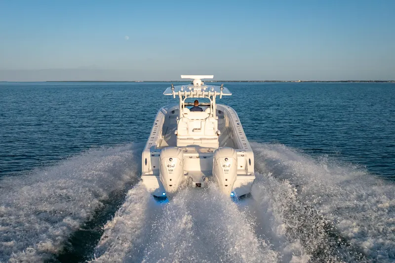 Slide: The Image of 2026 Freeman 35 boat cruising on open water, rear view with twin engines. - 3