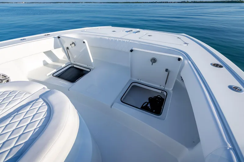 Slide: The Image of 2026 Freeman 35 boat deck with open storage compartments on calm water. - 40