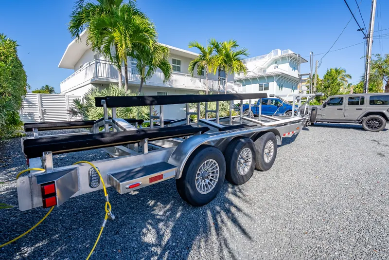 Slide: The Image of Trailer for Freeman 35 boat, 2026 model, parked on gravel near tropical house. - 59