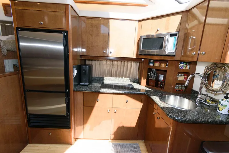 Slide: The Image of 2007 Carver 43 Motor Yacht kitchen with stainless steel appliances and wooden cabinetry. - 22