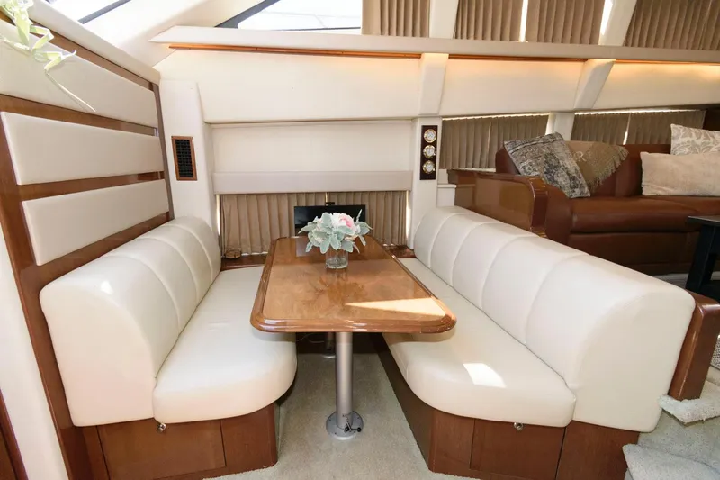 Slide: The Image of Luxurious dining area in 2007 Carver 43 Motor Yacht with leather seating and wooden table. - 21