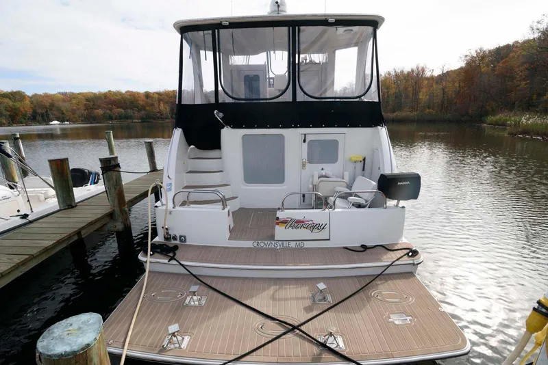 Slide: The Image of 2007 Carver 43 Motor Yacht docked on a serene lake with autumn foliage. - 5