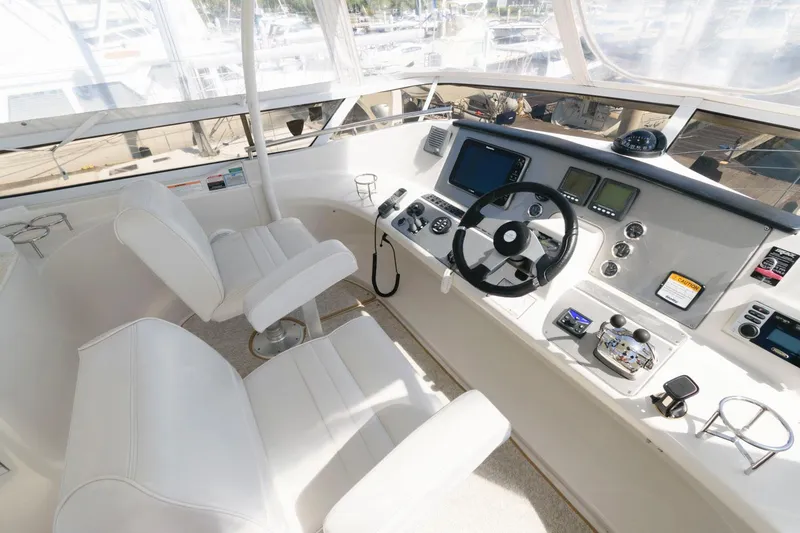 Slide: The Image of 2007 Carver 43 Motor Yacht helm with modern navigation equipment and white captain's chairs. - 8