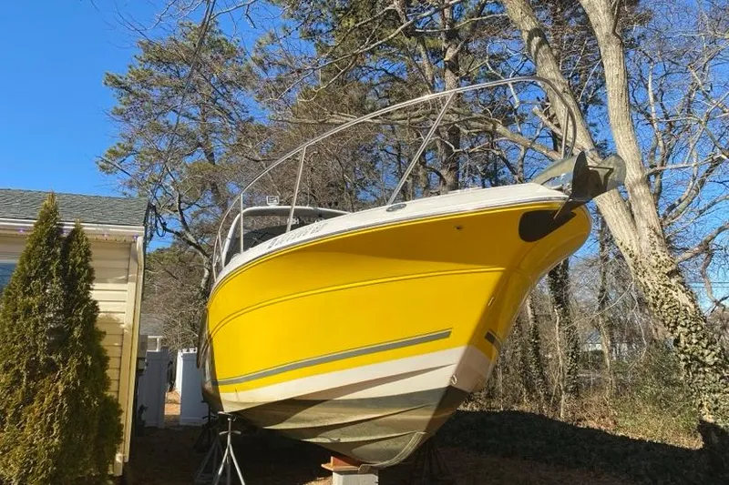 Slide: The Image of Yellow 2004 Monterey 282 Cruiser boat on land, surrounded by trees and a house. - 10