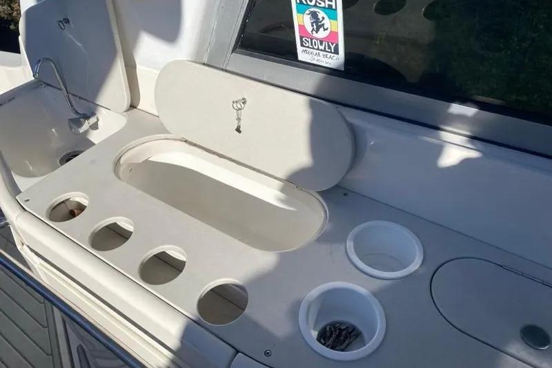 Slide: The Image of 2004 Monterey 282 Cruiser boat sink and storage area with cup holders. - 8