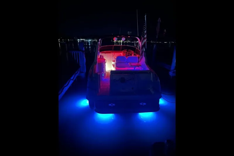 Slide: The Image of 2004 Monterey 282 Cruiser with vibrant blue and red lights at night dock. - 9
