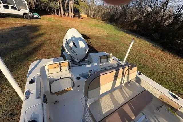 Slide: The Image of 2023 Sea Chaser 21 LX boat with seating and motor, parked on grassy area. - 6