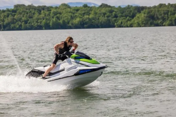 Slide: The Image of Person riding 2026 Yamaha WaveRunner VX Deluxe on a lake, surrounded by greenery. - 2