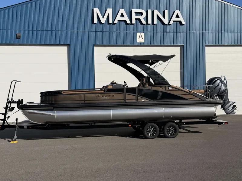 Slide: The Image of 2026 Bennington 25 RTSBA pontoon boat in front of marina building. - 17