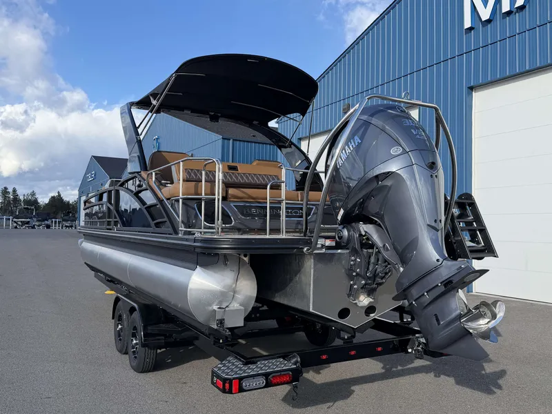 Slide: The Image of Bennington 25 RTSBA 2026 pontoon boat with Yamaha engine, on trailer near building. - 23