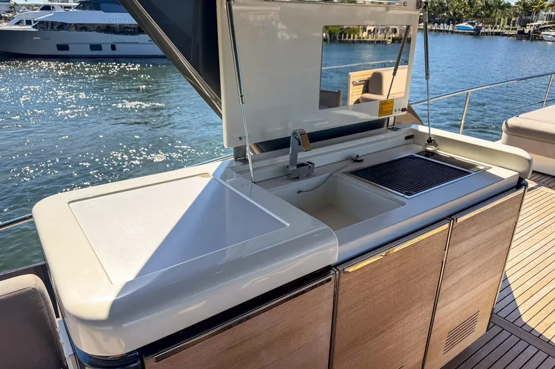 Slide: The Image of Outdoor kitchen on 2022 Prestige X70 yacht with sink and grill, docked by the water. - 17